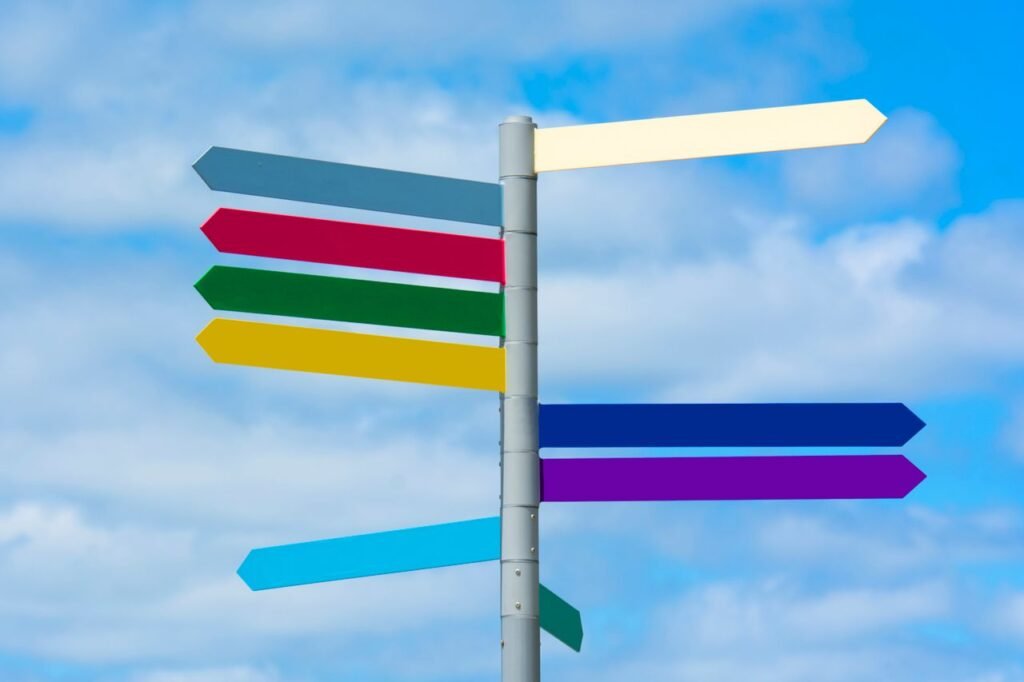 Vous travaillez au sein d'une entreprise Multicolored directional signpost against a vibrant blue sky, offering guidance.